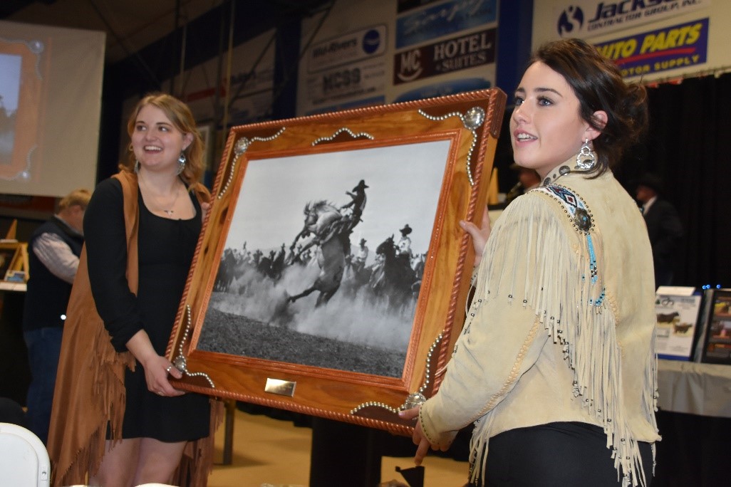 Image of two females holding art piece