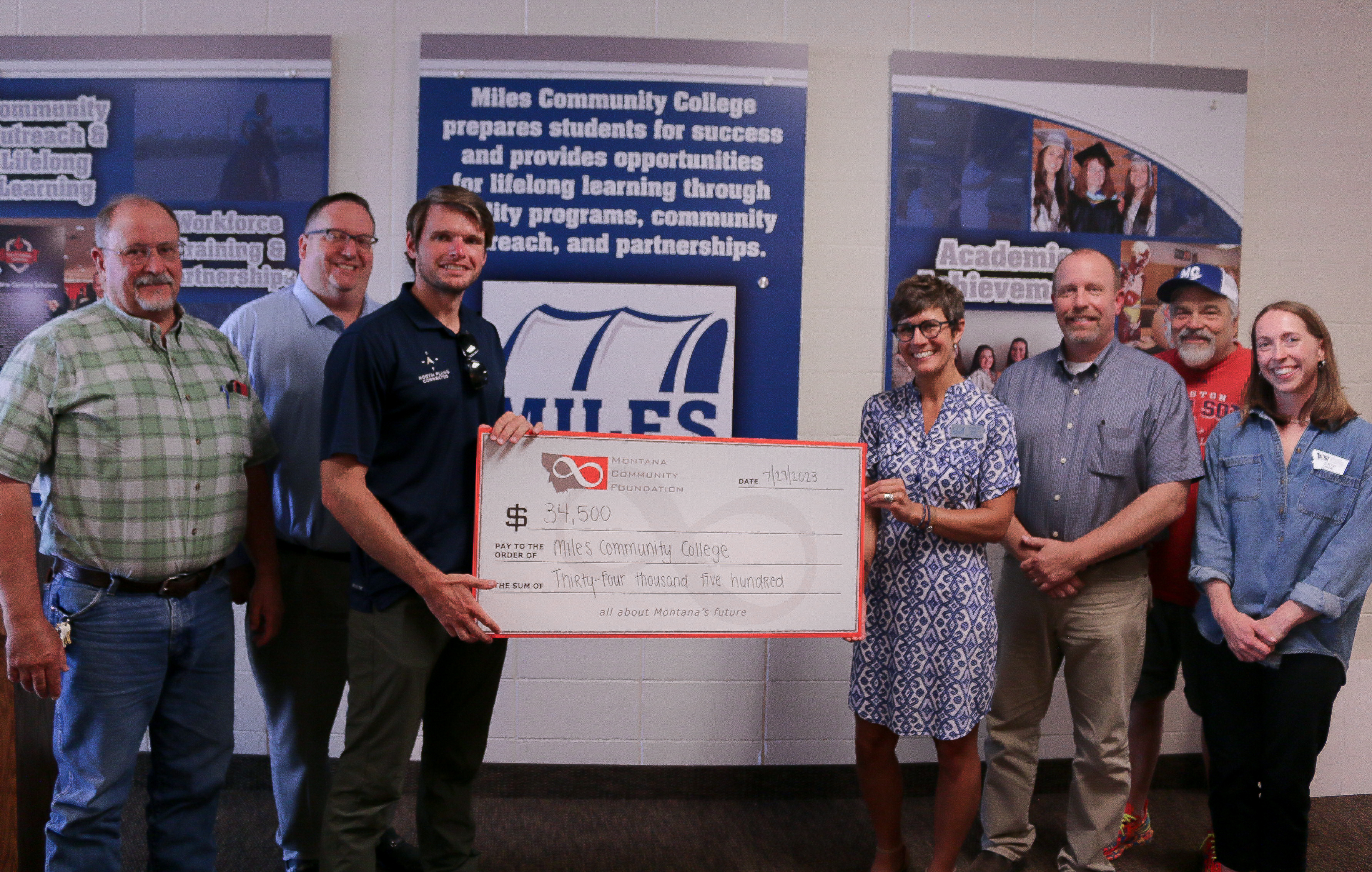 Group of adults holding an oversized check